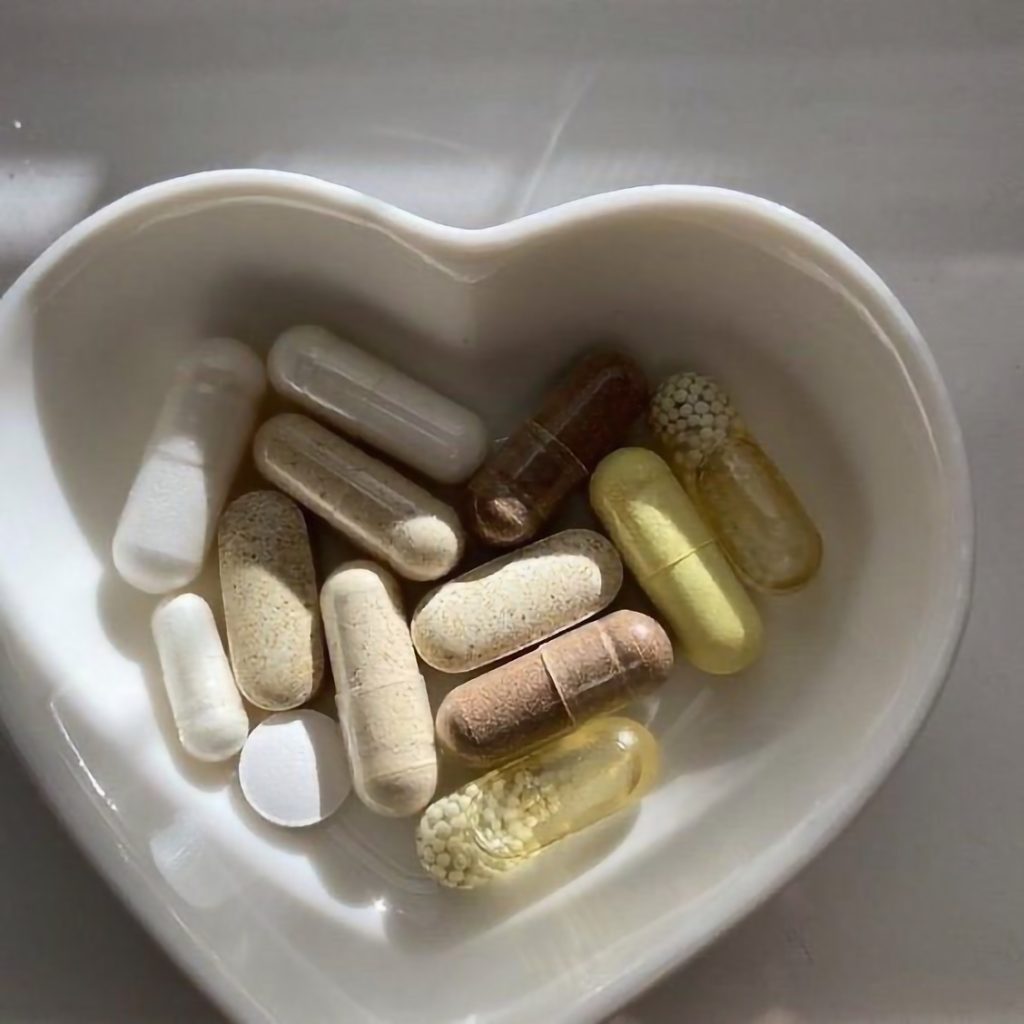 Heart shaped stone box filled with different types of pills Vitamin B12