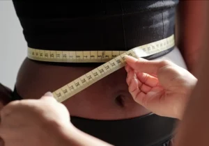 Skinny shots - Woman measuring her waste for Weight Loss
